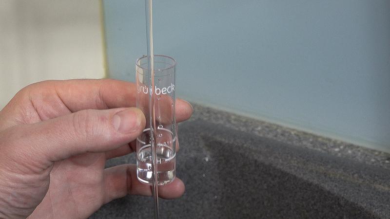 Wasser aus der Leitung in den Messbecher füllen